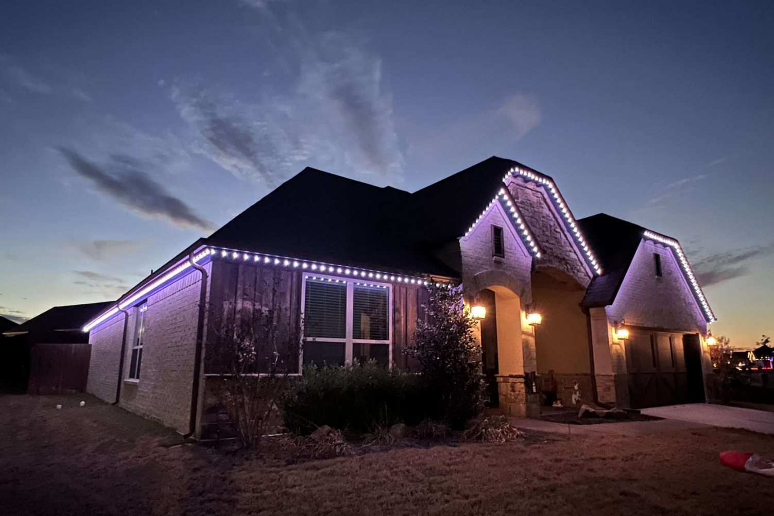 Modern single story house RGB roof lights warm porch dusk NEI Distributors North Reading MA.