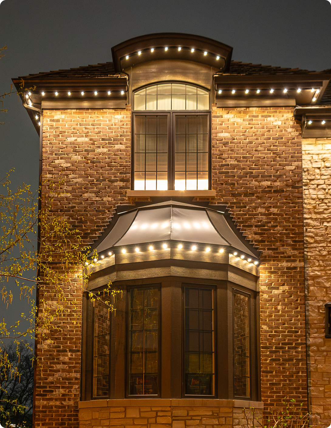 Brick house red stone accents large windows outlined lighting NEI Distributors North Reading MA.