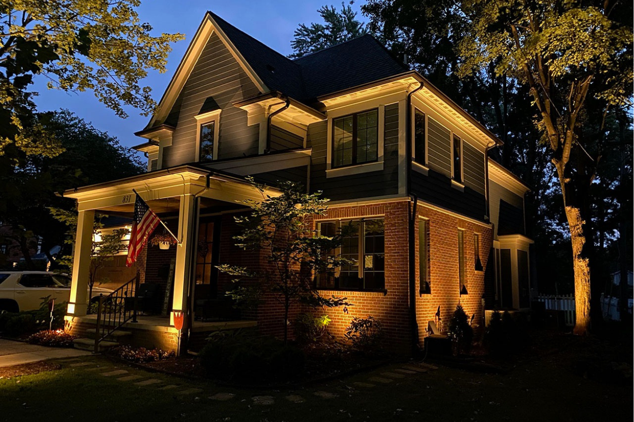 2700K LED landscape lighting for brick two story house with flag NEI Distributors North Reading MA.